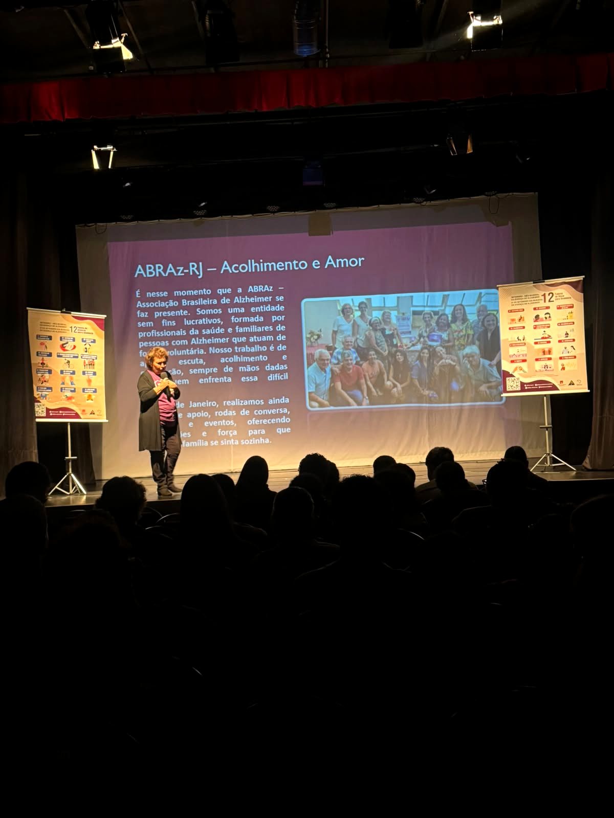 Apresentação com o slide Acolhimento e Amor projetado no palco