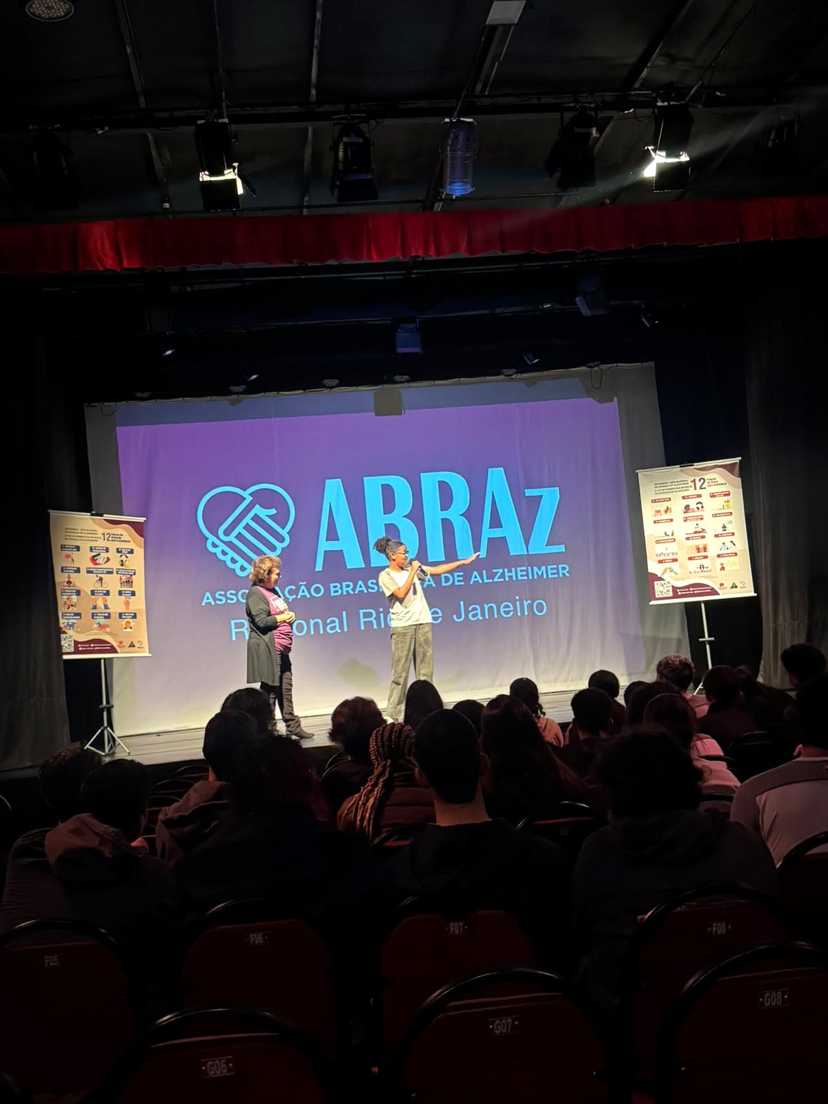 Plateia do teatro cheia durante a apresentação da ABRAz no palco
