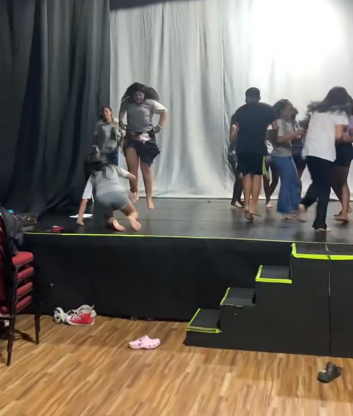 Crianças e adolescentes em exercício de movimento na aula de teatro