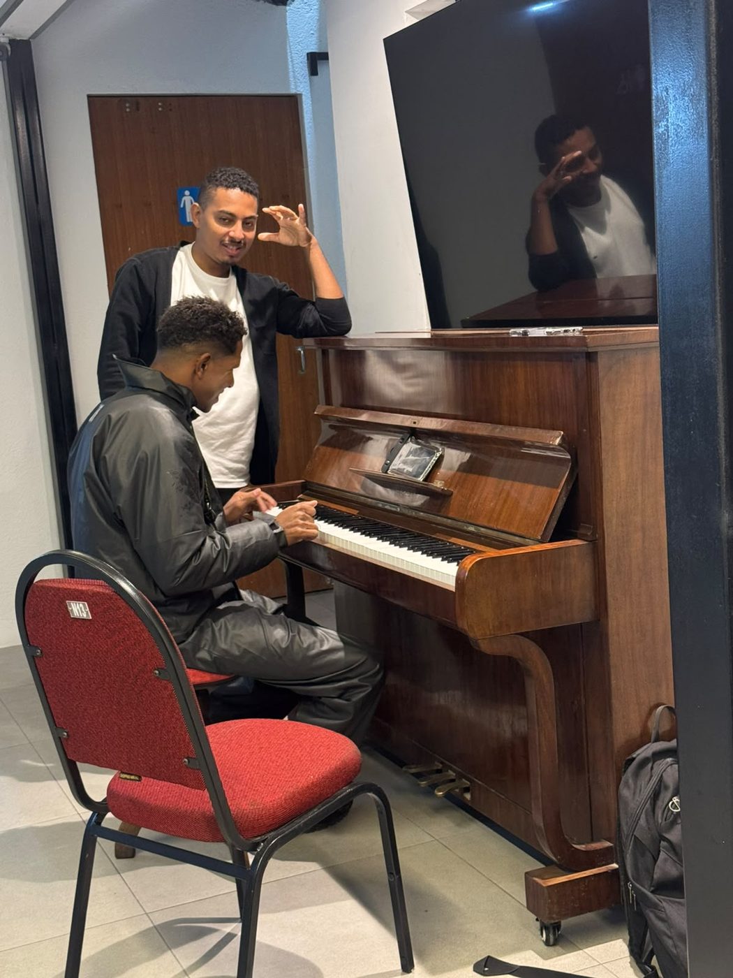 Professor orientando um aluno ao piano no Espaço Cultural Panorama