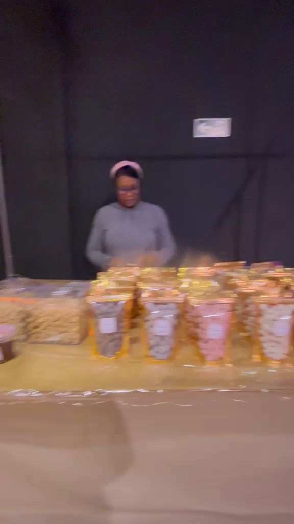 Empreendedora atrás da banca de doces no Encontro de Mães Empreendedoras